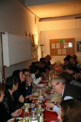 Menschen beim Essen an einer langen Tafel