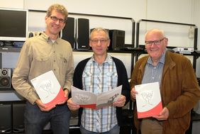 Matthias Merbecks, Wilfried Reiners, Hermann-Josef Kronen zeigen den Geschäftsbericht
